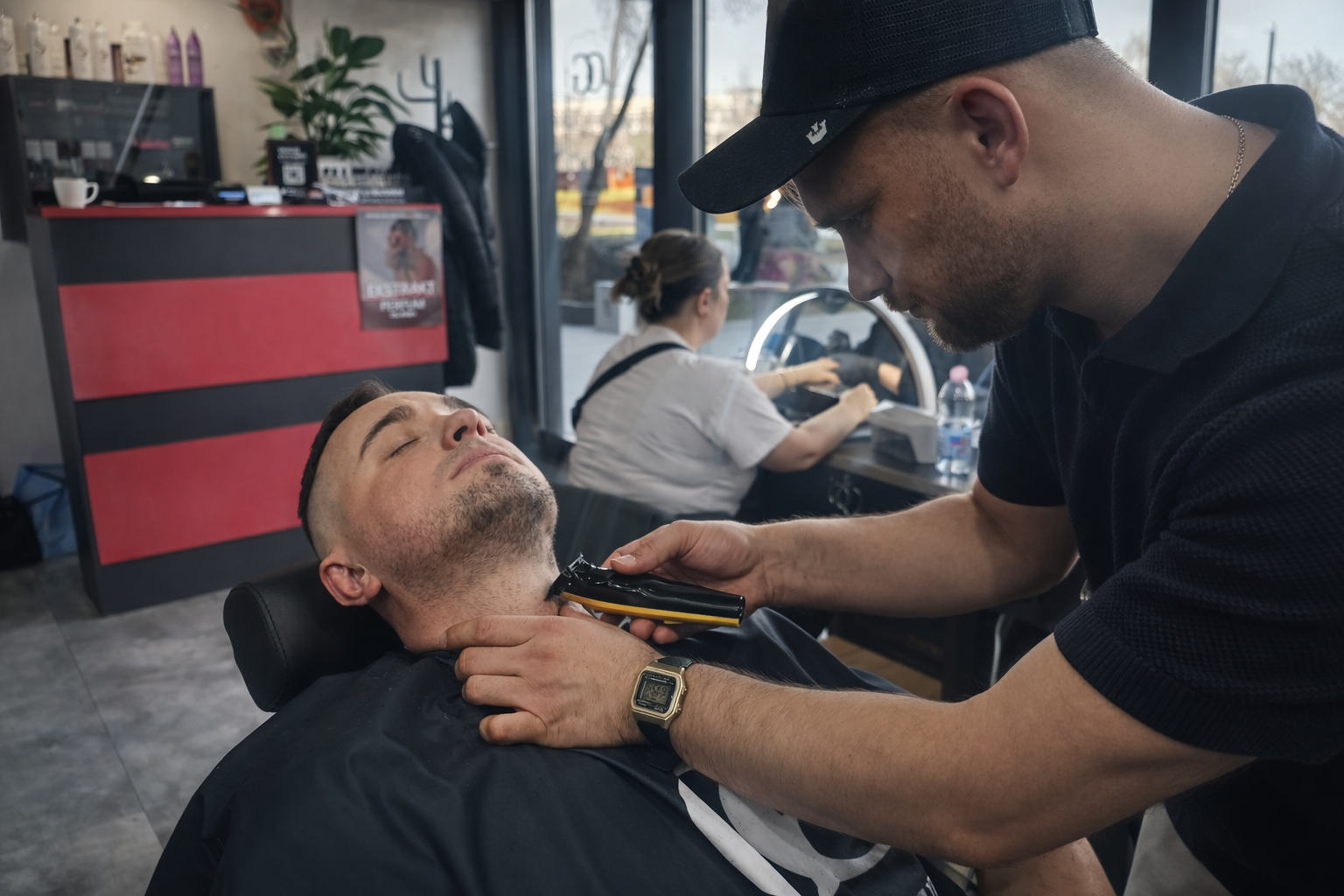 Barber przycina zarost na szyi klienta maszynką, wykonując dokładne i precyzyjne wykończenie fryzury w salonie barberskim
