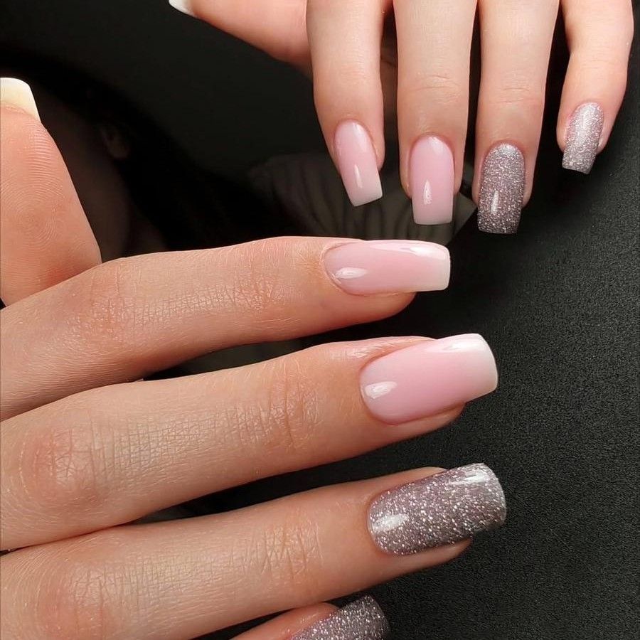Dłonie z paznokciami w jasnym różu z dodatkiem brokatowych akcentów, prezentujące elegancki i kobiecy manicure