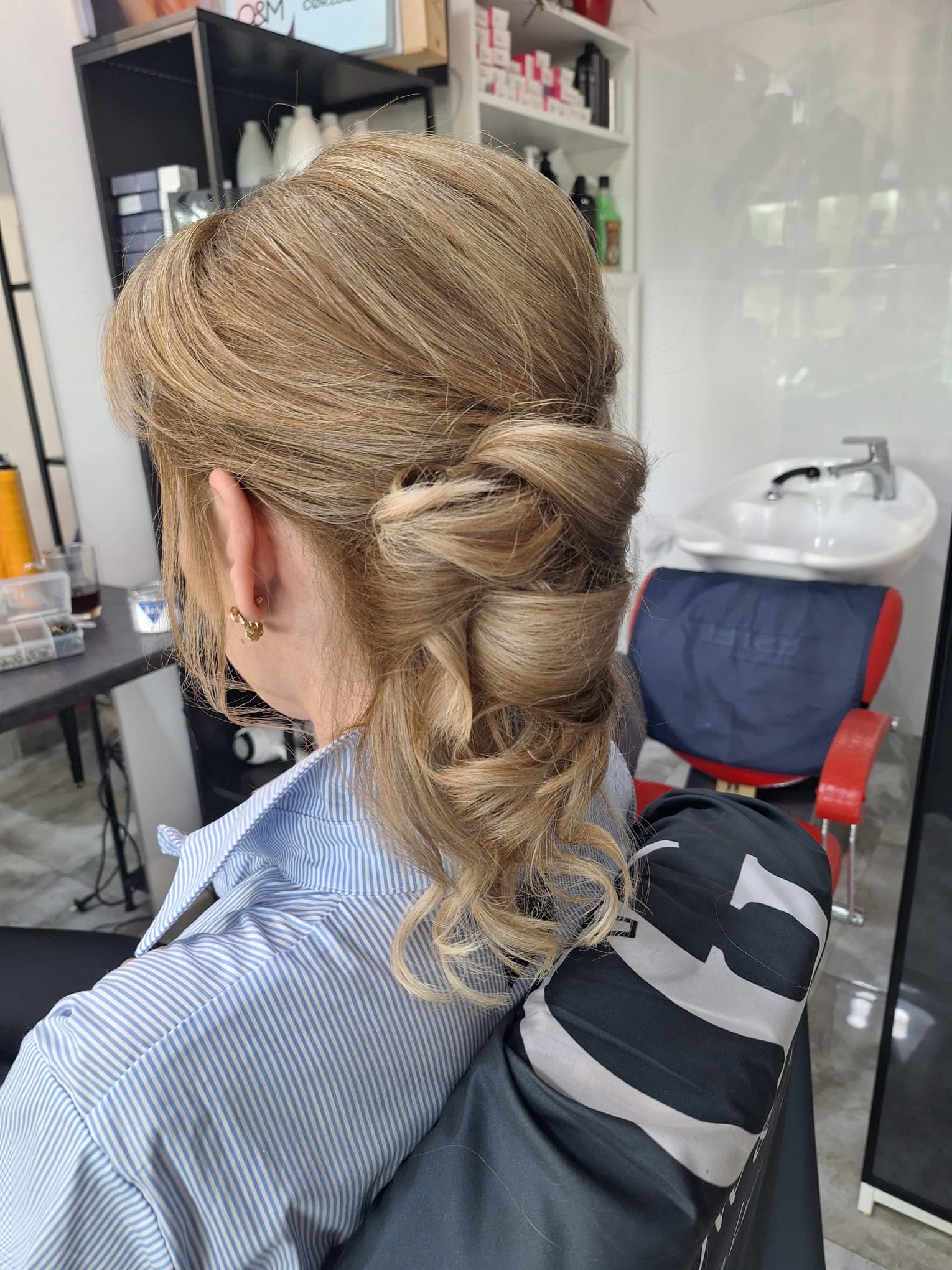 Eleganckie upięcie blond włosów z luźnymi lokami, przygotowane na wyjątkową okazję lub uroczystość.