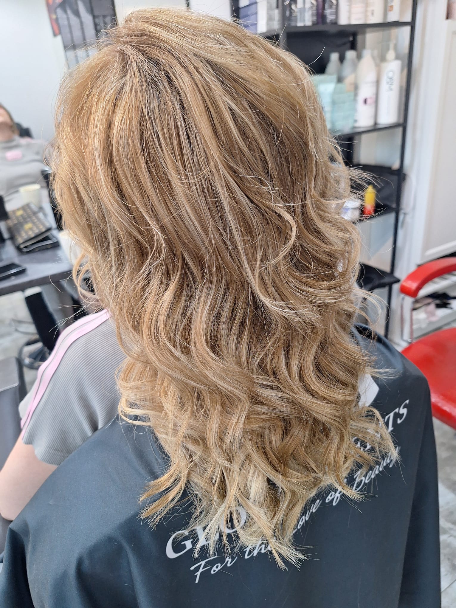 Jasny blond balayage z miękkimi falami i naturalnym przejściem kolorów po stylizacji fryzjerskiej.
